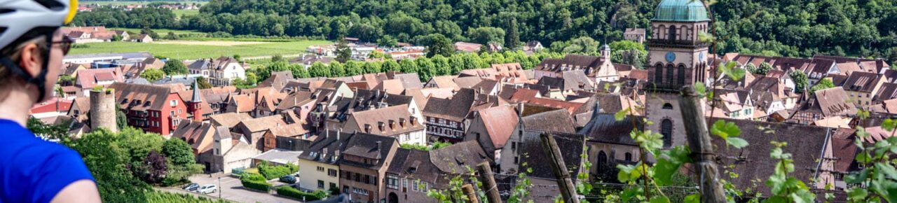 Cycliste observant la vue sur le village de Kaysersberg en Alsace