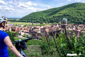 Cycliste observant la vue sur le village de Kaysersberg en Alsace